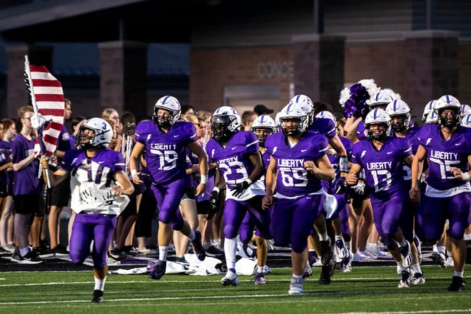 Iowa City Liberty players run on the field before a varsity high school football game against Iowa City High, Friday, Aug. 27, 2021, at Liberty High School in North Liberty, Iowa.
