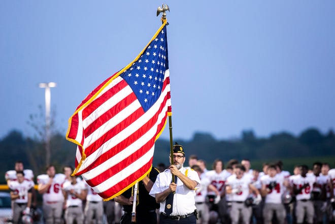 The American flag waves in the wind as the national anthem is performed before a varsity high school football game between Iowa City Liberty and Iowa City High, Friday, Aug. 27, 2021, at Liberty High School in North Liberty, Iowa.