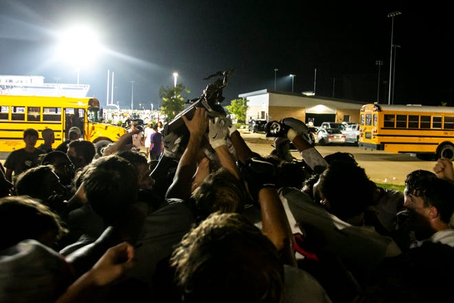 Iowa City High players celebrate with the Titans Trophy after a varsity high school football game against Iowa City Liberty, Friday, Aug. 27, 2021, at Liberty High School in North Liberty, Iowa. The Little Hawks beat the Lightning, 41-0.