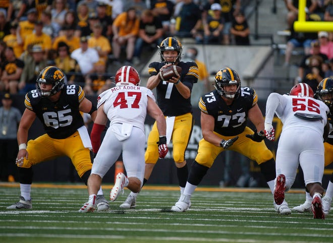 Iowa junior center Tyler Linderbaum (No. 65, left) and junior guard Cody Ince (No. 73, right) offer protection for junior quarterback Spencer Petras in the third quarter against Indiana at Kinnick Stadium in Iowa City on Saturday, Sept. 4, 2021.