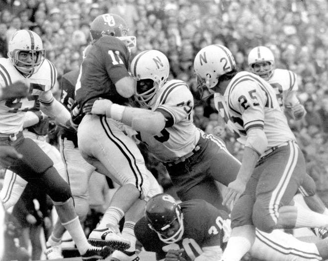 FILE - In this Nov. 25, 1971, file photo, Nebraska's Rich Glover (79) brings down Oklahoma quarterback Jack Mildren (11) as Nebraska defenders Bob Terrio (45) and Dave Mason (25) close in during a college football game in Norman, Okla., on Thanksgiving Day. The game on Thanksgiving 50 years ago is back in the spotlight as Nebraska and Oklahoma renew their rivalry on Saturday, Sept. 18, 2021. (Lincoln Journal Star via AP, File) ORG XMIT: NELIN902