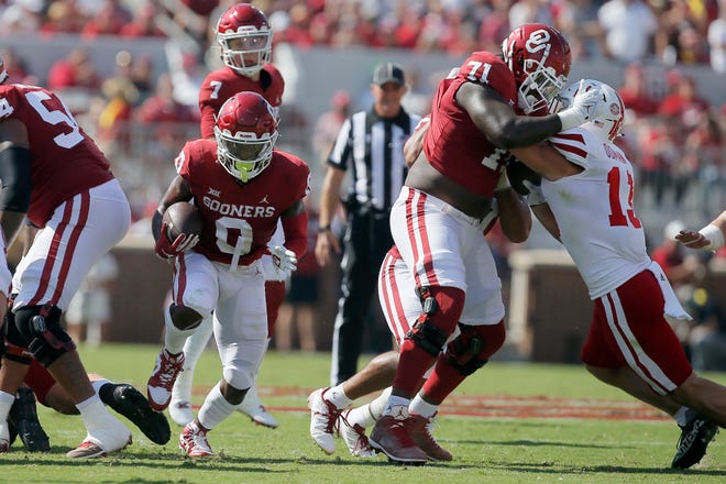 OU's Eric Gray (0) runs through a gap created by offensive linemen 
Marquis Hayes (54) and Anton Harrison (71) against Nebraska on Sept. 18, 2021.