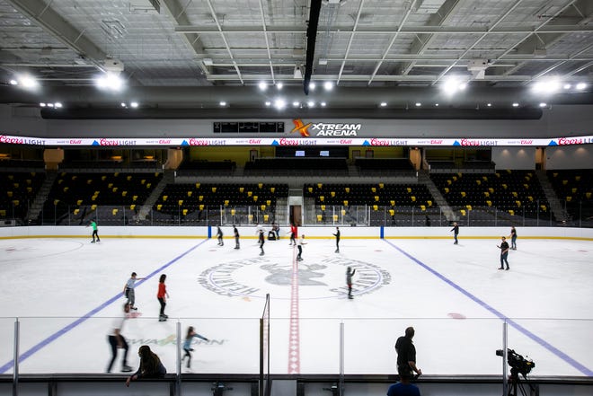 The Iowa Heartlanders logo is seen at center ice as people skate around the hockey rink during an event unveiling the instillation of ice, Tuesday, Sept. 28, 2021, at the Xtream Arena in Coralville, Iowa.