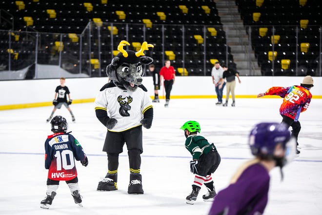 The Iowa Heartlanders mascot greets some young hockey fans during an event unveiling the instillation of ice, Tuesday, Sept. 28, 2021, at the Xtream Arena in Coralville, Iowa.