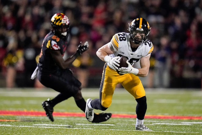 Iowa defensive back Jack Koerner, right, runs with the ball after making an interception on a pass during an NCAA college football game, Friday, Oct. 1, 2021, at Capital One Field at Maryland Stadium in College Park, Maryland.