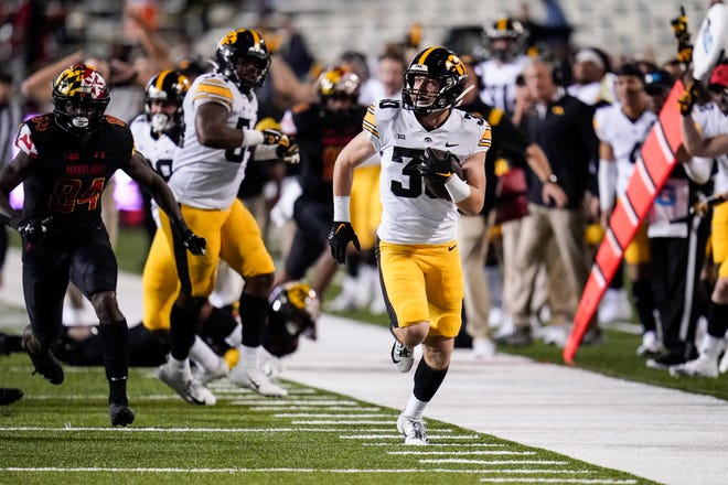 Iowa defensive back Quinn Schulte (30) runs with the ball after making an interception against Maryland during an NCAA college football game, Friday, Oct. 1, 2021, at Capital One Field at Maryland Stadium in College Park, Maryland.