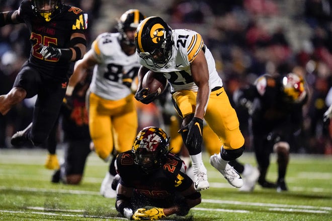Iowa running back Ivory Kelly-Martin (21) avoids a tackle by Maryland defensive back Dante Trader (20) during an NCAA college football game, Friday, Oct. 1, 2021, at Capital One Field at Maryland Stadium in College Park, Maryland.