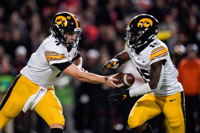 Iowa quarterback Spencer Petras, left, hands off to running back Tyler Goodson during an NCAA college football game, Friday, Oct. 1, 2021, at Capital One Field at Maryland Stadium in College Park, Maryland.