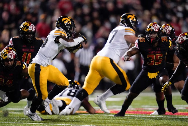 Iowa running back Tyler Goodson, left, runs with the ball against Maryland during an NCAA college football game, Friday, Oct. 1, 2021, at Capital One Field at Maryland Stadium in College Park, Maryland.