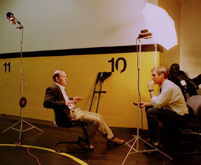 A corner of the University of Iowa wrestling room becomes a temporary studio as ESPN's Steve Cyphers interviews Dan Gable in 1997. The prospect of the coach's departure from his U of I position has drawn interest from CNN, ESPN, a documentary crew and others.