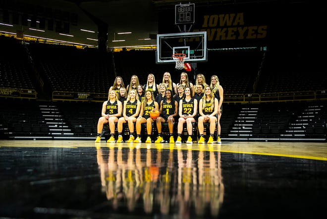 Iowa head coach Lisa Bluder poses for a photo with players during Hawkeyes NCAA college women's basketball media day, Thursday, Oct. 28, 2021, at Carver-Hawkeye Arena in Iowa City, Iowa.