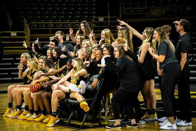 Iowa head coach Lisa Bluder poses for a photo with players during Hawkeyes NCAA college women's basketball media day, Thursday, Oct. 28, 2021, at Carver-Hawkeye Arena in Iowa City, Iowa.