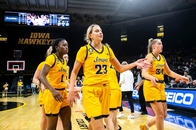 Iowa Hawkeyes players Tomi Taiwo (1) Logan Cook (23) and AJ Ediger (34) walk off the court to greet teammates after a NCAA women's basketball exhibition game against Truman State, Thursday, Nov. 4, 2021, at Carver-Hawkeye Arena in Iowa City, Iowa.