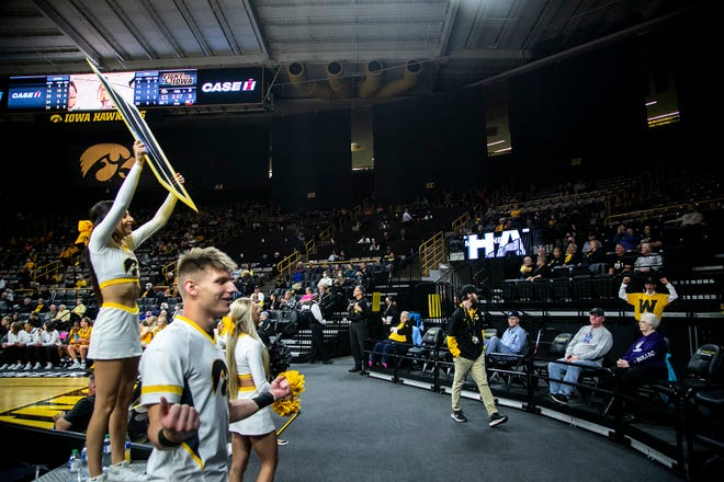 An Iowa cheerleader holds up a W card while doing a chant during a NCAA women's basketball exhibition game against Truman State, Thursday, Nov. 4, 2021, at Carver-Hawkeye Arena in Iowa City, Iowa.