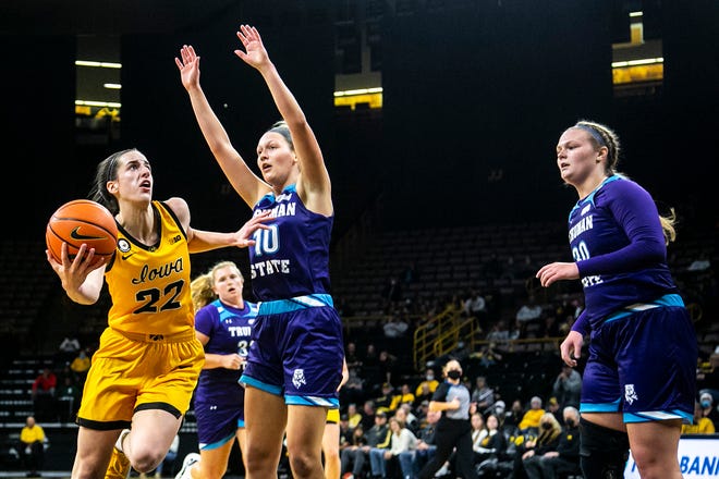 Iowa guard Caitlin Clark (22) drives to the basket against Truman State's Hannah Pinkston (10) as Madison Niemeier, right, looks on during a NCAA women's basketball exhibition game, Thursday, Nov. 4, 2021, at Carver-Hawkeye Arena in Iowa City, Iowa.