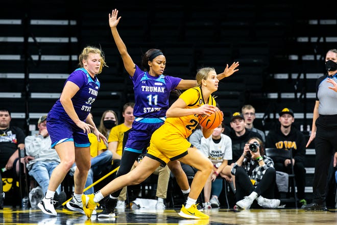 Iowa forward Logan Cook (23) looks to pass as Truman State's Katey Klucking, left, and Brioenne Burns (11) defend during a NCAA women's basketball exhibition game, Thursday, Nov. 4, 2021, at Carver-Hawkeye Arena in Iowa City, Iowa.
