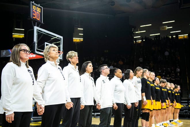 Iowa Hawkeyes coaches including head coach Lisa Bluder, second from left, hold hands with players as the national anthem is played before a NCAA women's basketball exhibition game against Truman State, Thursday, Nov. 4, 2021, at Carver-Hawkeye Arena in Iowa City, Iowa.