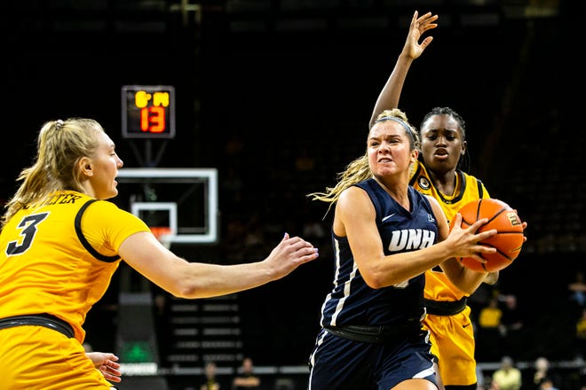 New Hampshire's Amanda Torres drives to the basket as Iowa guards Tomi Taiwo, right, and Sydney Affolter (3) defend during a NCAA non-conference women's basketball game, Tuesday, Nov. 9, 2021, at Carver-Hawkeye Arena in Iowa City, Iowa.