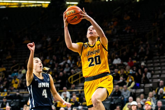 Iowa guard Kate Martin (20) drives to the basket as New Hampshire's Ivy Gogolin (4) defends during a NCAA non-conference women's basketball game, Tuesday, Nov. 9, 2021, at Carver-Hawkeye Arena in Iowa City, Iowa.