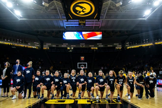 New Hampshire players kneel as the national anthem is performed before a NCAA non-conference women's basketball game against Iowa, Tuesday, Nov. 9, 2021, at Carver-Hawkeye Arena in Iowa City, Iowa.