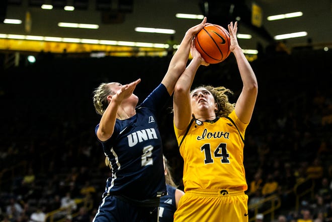 Iowa's McKenna Warnock (14) gets fouled by New Hampshire's Brooke Kane (2) during a NCAA non-conference women's basketball game, Tuesday, Nov. 9, 2021, at Carver-Hawkeye Arena in Iowa City, Iowa.