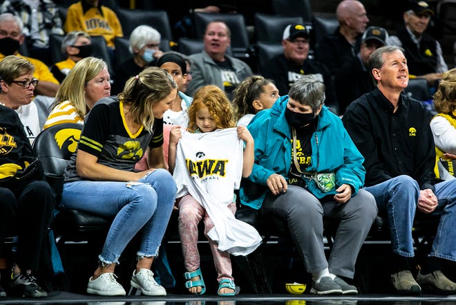 An Iowa Hawkeyes fan checks out their a T-shirt they caught during a NCAA non-conference women's basketball game against New Hampshire, Tuesday, Nov. 9, 2021, at Carver-Hawkeye Arena in Iowa City, Iowa.