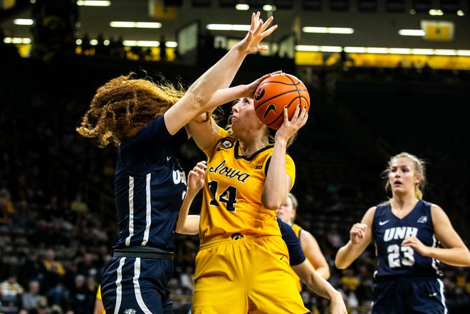 Iowa's McKenna Warnock (14) drives to the basket against New Hampshire's Bella Stuart, left, during a NCAA non-conference women's basketball game, Tuesday, Nov. 9, 2021, at Carver-Hawkeye Arena in Iowa City, Iowa.