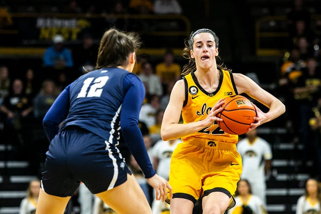 Iowa guard Caitlin Clark looks to pass as New Hampshire's Adara Groman (12) defends during a NCAA non-conference women's basketball game, Tuesday, Nov. 9, 2021, at Carver-Hawkeye Arena in Iowa City, Iowa.