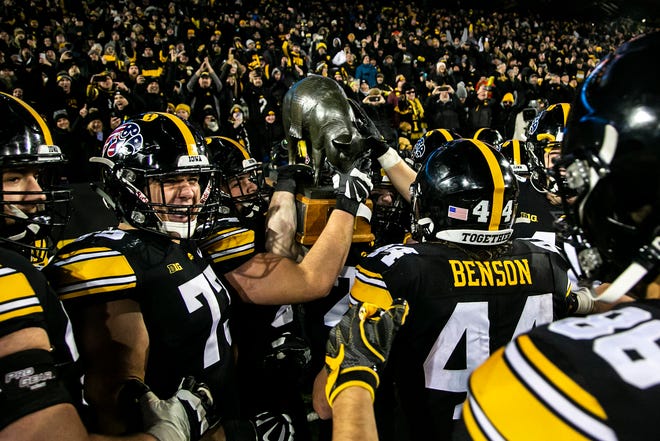 Iowa Hawkeyes players celebrate with the Floyd of Rosedale trophy after a NCAA Big Ten Conference football game against Minnesota, Saturday, Nov. 13, 2021, at Kinnick Stadium in Iowa City, Iowa. The Hawkeyes beat the Golden Gophers, 27-22.