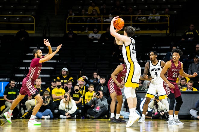 Iowa forward Patrick McCaffery (22) makes a 3-point basket as North Carolina Central's Nicolas Fennell, left, and Eric Boone defend during a NCAA non-conference men's basketball game, Tuesday, Nov. 16, 2021, at Carver-Hawkeye Arena in Iowa City, Iowa.