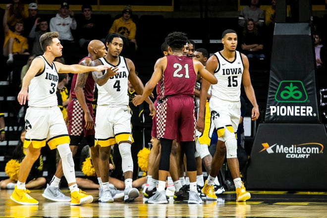 Iowa guard Jordan Bohannon (3) high-fives teammate Ahron Ulis (4) while walking off the court with Keegan Murray (15) at the end of the first half during a NCAA non-conference men's basketball game against North Carolina Central, Tuesday, Nov. 16, 2021, at Carver-Hawkeye Arena in Iowa City, Iowa.