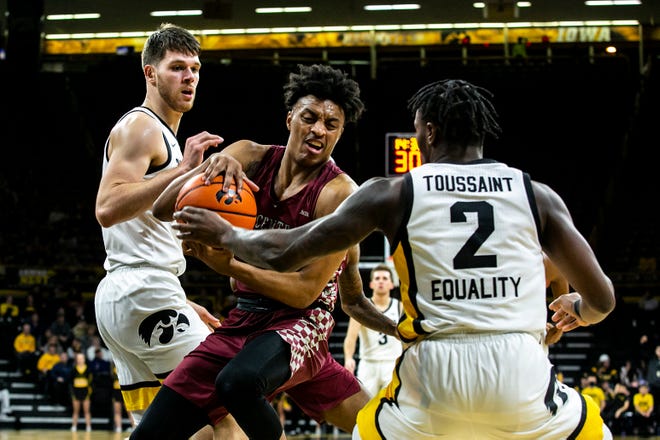 North Carolina Central's Eric Boone, center, pulls down a rebound against Iowa forward Filip Rebraca, left, and guard Joe Toussaint (2) during a NCAA non-conference men's basketball game, Tuesday, Nov. 16, 2021, at Carver-Hawkeye Arena in Iowa City, Iowa.