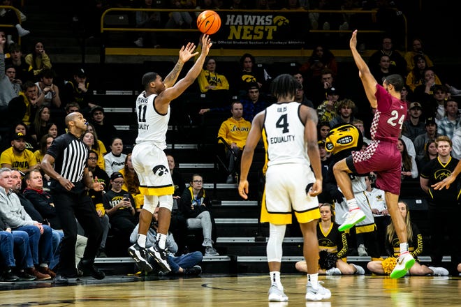 Iowa guard Tony Perkins (11) makes a 3-point basket as North Carolina Central's Nicolas Fennell (24) defends during a NCAA non-conference men's basketball game, Tuesday, Nov. 16, 2021, at Carver-Hawkeye Arena in Iowa City, Iowa.