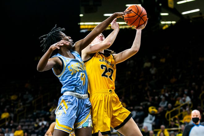 Iowa guard Caitlin Clark (22) gets fouled by Southern University's Chloe Fleming (4) during a NCAA non-conference women's basketball game, Wednesday, Nov. 17, 2021, at Carver-Hawkeye Arena in Iowa City, Iowa.