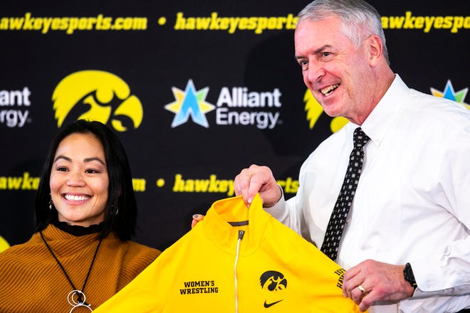 Clarissa Chun, left, and Iowa athletic director Gary Barta pose for a photo with during a news conference announcing Chun as the head coach for the women's wrestling program, Friday, Nov. 19, 2021, at Carver-Hawkeye Arena in Iowa City, Iowa.