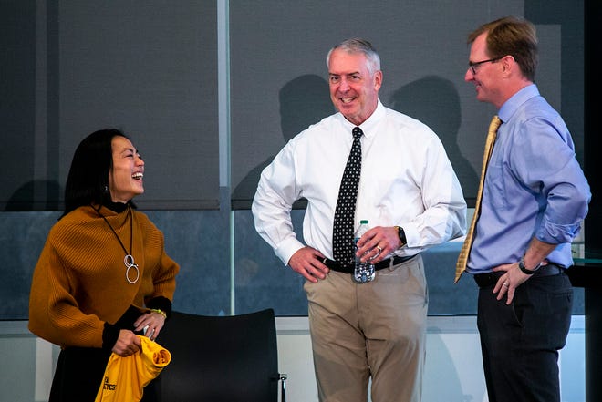 Clarissa Chun, left, Iowa athletic director Gary Barta, and Chris Brewer, associate director of athletic communications, talk after during a news conference announcing Chun as the head coach for the women's wrestling program, Friday, Nov. 19, 2021, at Carver-Hawkeye Arena in Iowa City, Iowa.