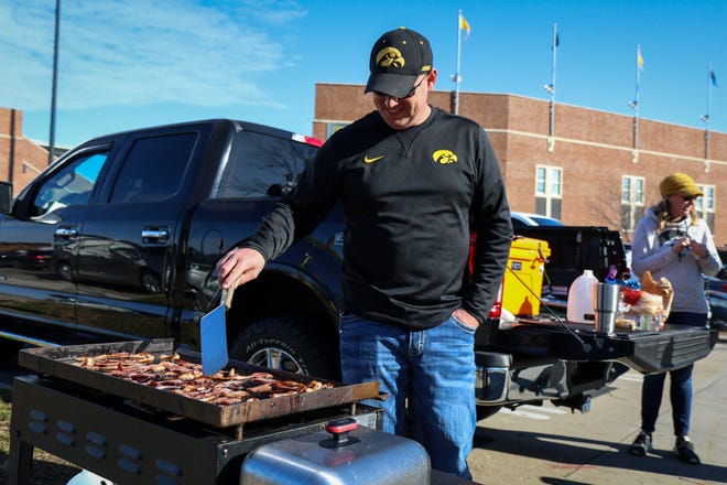 Senica Fisher, of Marion, grills up some bacon while tailgating outside Kinnick Stadium before the Iowa football game against Illinois in Iowa City on Sat., Nov. 20, 2021.