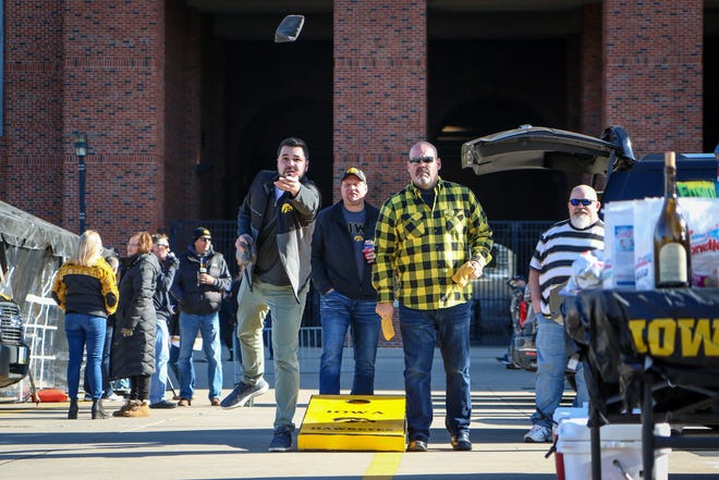 Andrew Burnham, left, of Pleasant Valley, plays bags while tailgating outside Kinnick Stadium before the Iowa football game against Illinois in Iowa City on Sat., Nov. 20, 2021.