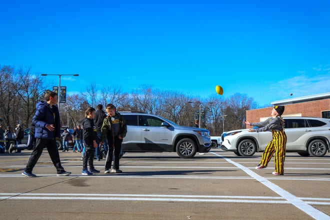 Young tailgaters play catch with a football outside Kinnick Stadium before the Iowa football game against Illinois in Iowa City on Sat., Nov. 20, 2021.
