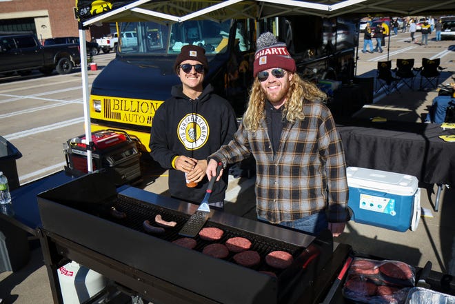 Kyden Martinez, left, and Brian Haight, right, of Iowa City, grill up some burgers and brats while tailgating before the Iowa football game against Illinois in Iowa City on Sat., Nov. 20, 2021.