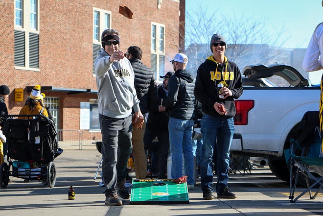 Denny Doud, left, and Jarod Doud, right, of Ankeny, play some bags while tailgating outside Kinnick Stadium before the Iowa football game against Illinois in Iowa City on Sat., Nov. 20, 2021.