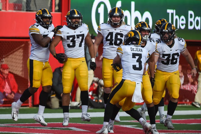 Iowa defensive back Kyler Fisher (37) of the Iowa Hawkeyes celebrates with teammates Cooper DeJean (3) and Logan Klemp (46) after scoring on a blocked punt against the Nebraska Cornhuskers in the second half, Friday, Nov. 26, 2021, at Memorial Stadium, in Lincoln, Neb.