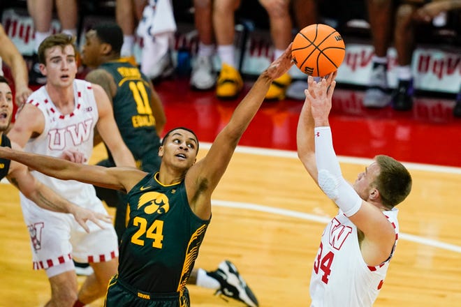 Wisconsin's Brad Davison (34) shoots against Iowa's Kris Murray (24) during the first half of an NCAA college basketball game Thursday, Thursday, Jan. 6, 2022, at the Kohl Center in Madison, Wis.