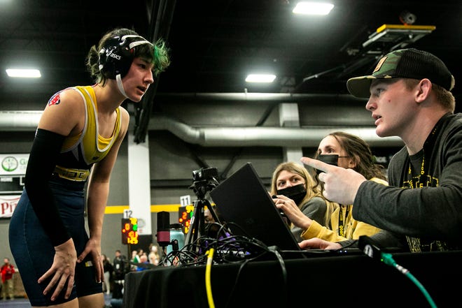 Iowa City Regina's Alex Spies checks in with table officials before wrestling at 130 pounds during the first session of the Iowa Wrestling Coaches and Officials Association (IWCOA) girls' state wrestling tournament, Friday, Jan. 21, 2022, at the Xtream Arena in Coralville, Iowa.