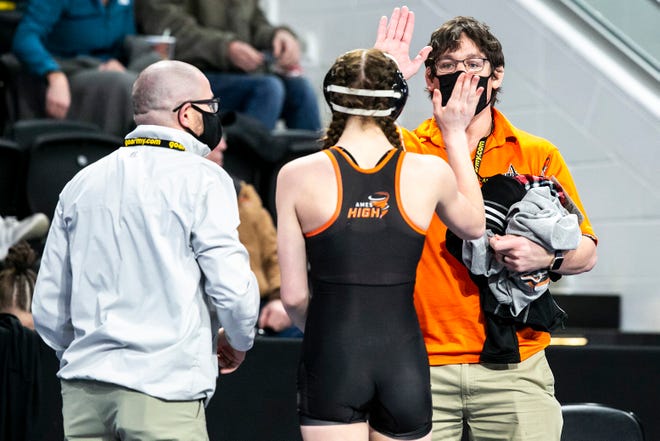 Ames' Alexis Winkey high-fives coaches after a match at 125 pounds during the first session of the Iowa Wrestling Coaches and Officials Association (IWCOA) girls' state wrestling tournament, Friday, Jan. 21, 2022, at the Xtream Arena in Coralville, Iowa.