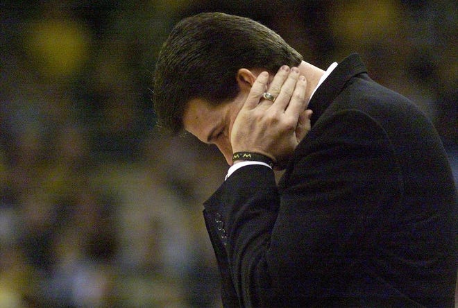 Iowa men's basketball coach Steve Alford puts his head on his hands after he watched his team make an error against Wisconsin during their game, Jan. 2, 2002, at Carver-Hawkeye Arena in Iowa City.