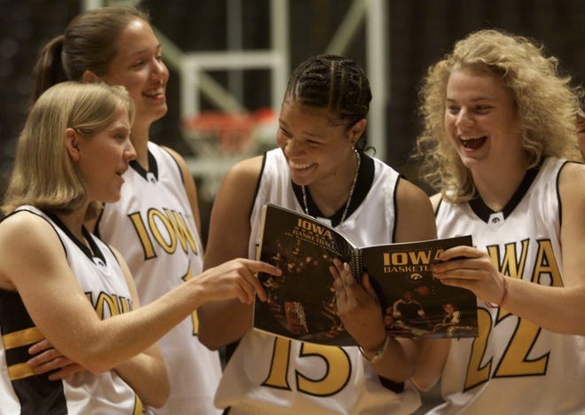 2000: From left, Kristi Faulkner, Amber O'Brien, Patrice Jennings and Mary Berdo of the Iowa women's basketball team get a chuckle out of a picture in the team's media guide at Carver-Hawkeye Arena in Iowa City.