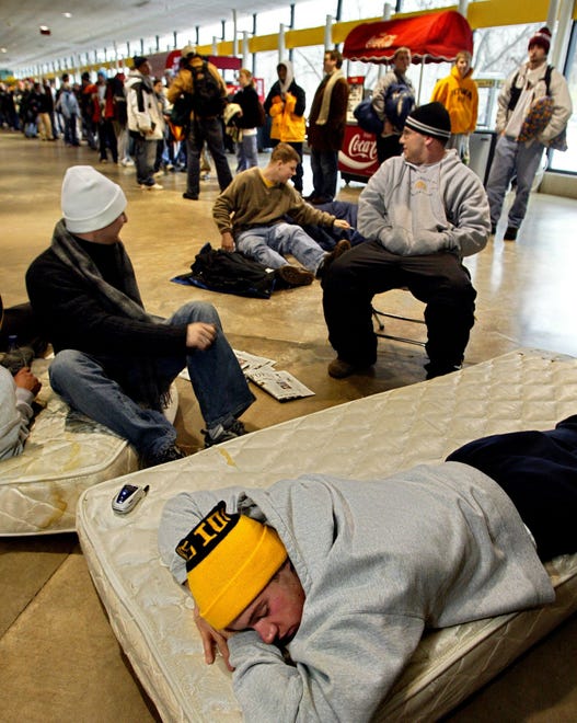 Brad Downes, 22, of Bettendorf tries to sleep in Carver-Hawkeye Arena on Friday, Dec. 12, 2003, while waiting to buy Outback Bowl tickets. He and some friends plopped down a pair of mattresses at 5:15 a.m. Tickets went on sale at 8 a.m. for the Jan. 1 game against the Florida Gators.