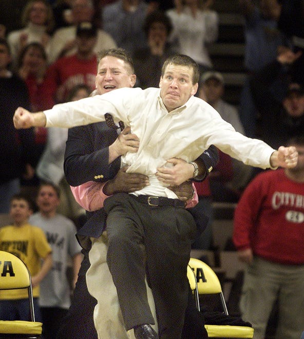 Iowa assistant coach Tom Brands, right, is restrained by assistant Royce Alger as he celebrates Ryan Fulsaas' victory over Minnesota's Damion Hahn in the 197 pound match clenching Iowa's victory over rival Minnesota in 2003.
