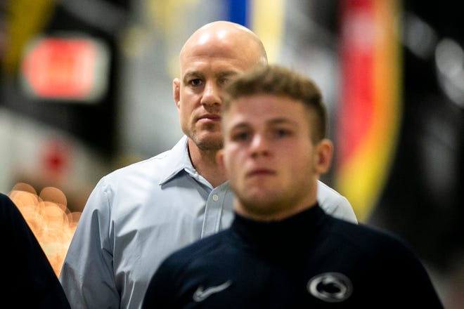 Penn State head coach Cael Sanderson, left, walks down the tunnel before a NCAA Big Ten Conference wrestling dual against Iowa, Friday, Jan. 28, 2022, at Carver-Hawkeye Arena in Iowa City, Iowa.